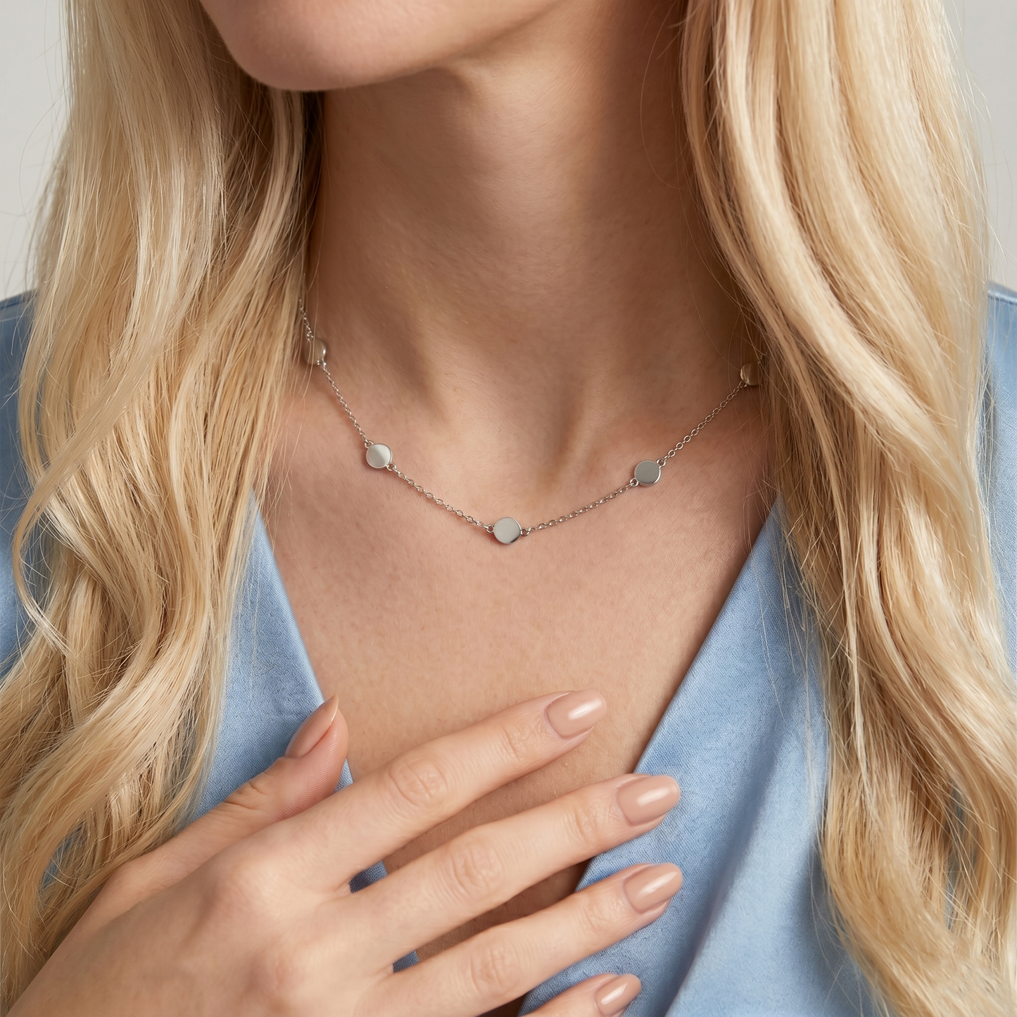 Silver round-disc choker necklace on a model’s neck with link chain
