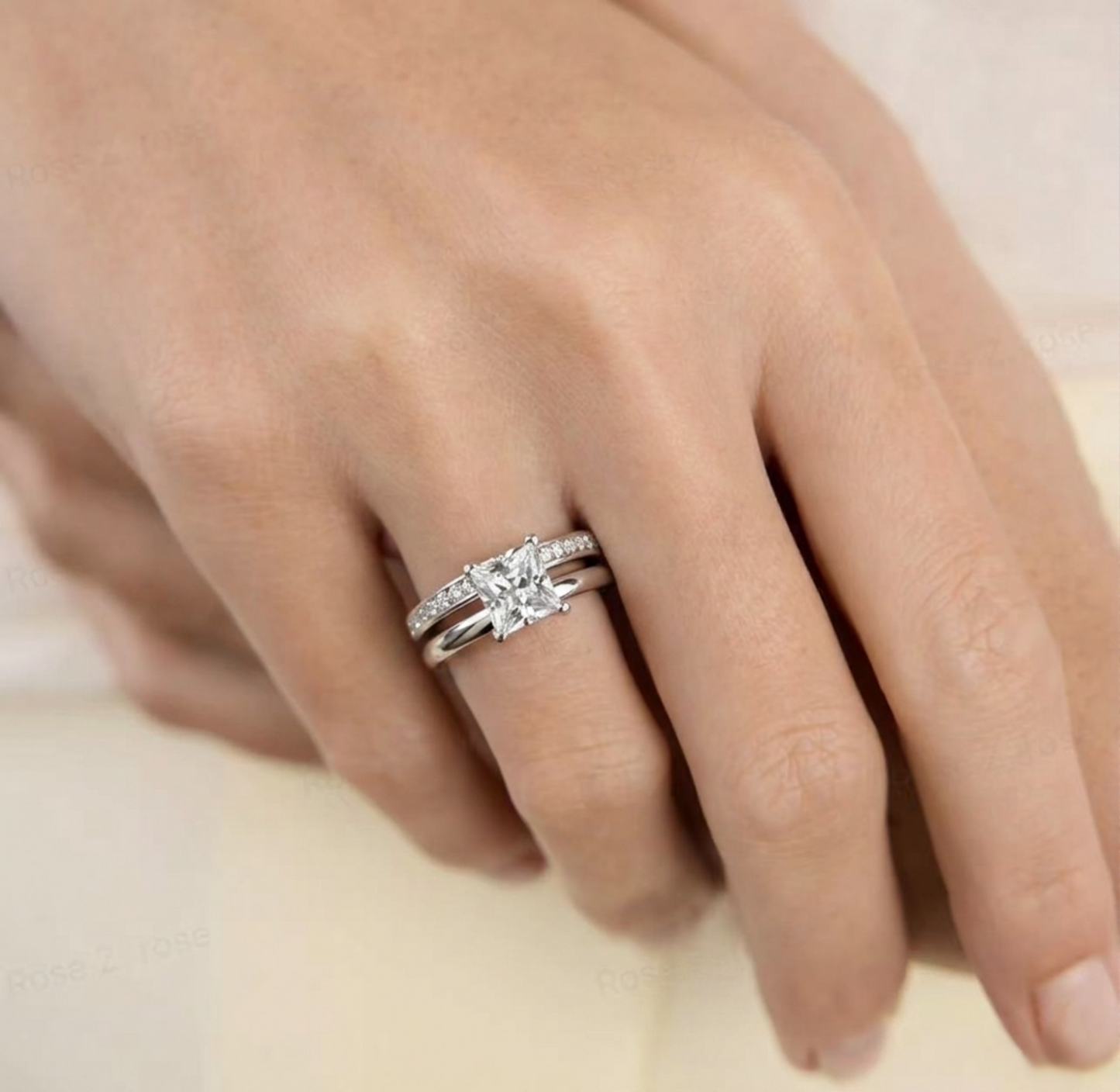 Silver eternity ring with a larger center stone and channel-set side stones on finger