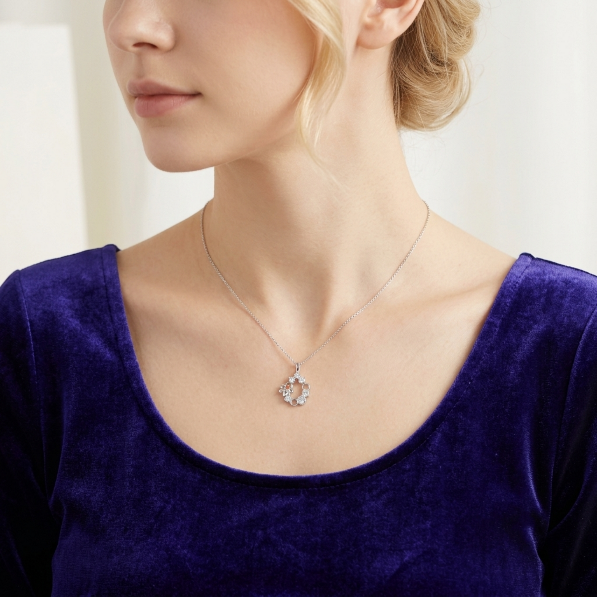 Silver-tone bee honeycomb pendant necklace worn on a model