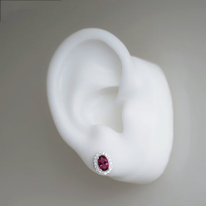 Ruby-red CZ stud earring with oval center stone and silver halo setting