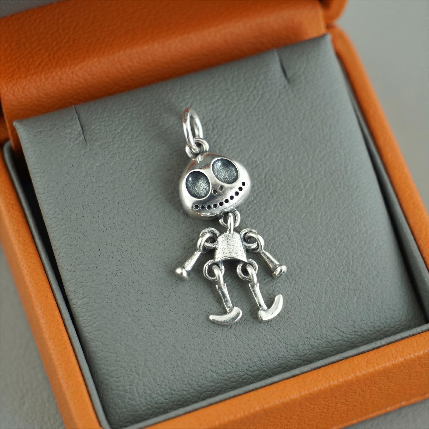 Movable ghost pendant with oval head and small teeth, silver-tone articulated parts