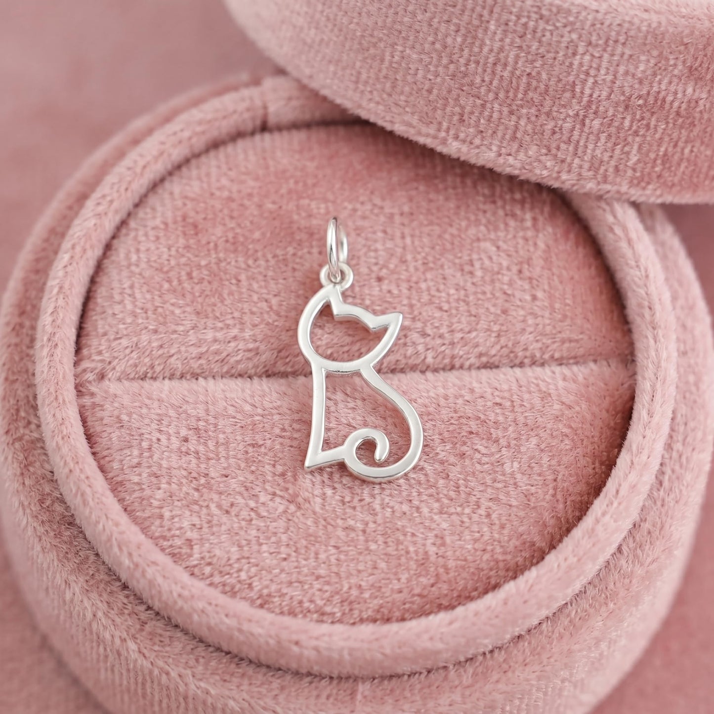 Silver-tone hollow kitten charm on pink velvet cord, with loop bail at top.