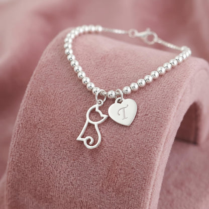 Beaded necklace with silver-tone hollow kitten charm and heart charm, small clasp.