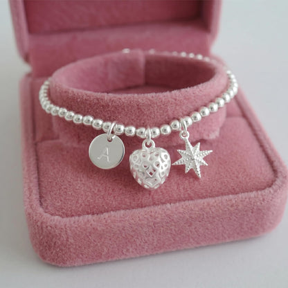 Heart pendant charm with cut-out pattern on bead bracelet with star charm
