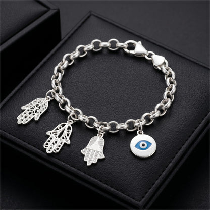 Silver charm bracelet featuring small hamsa hand charms and an blue eye charm