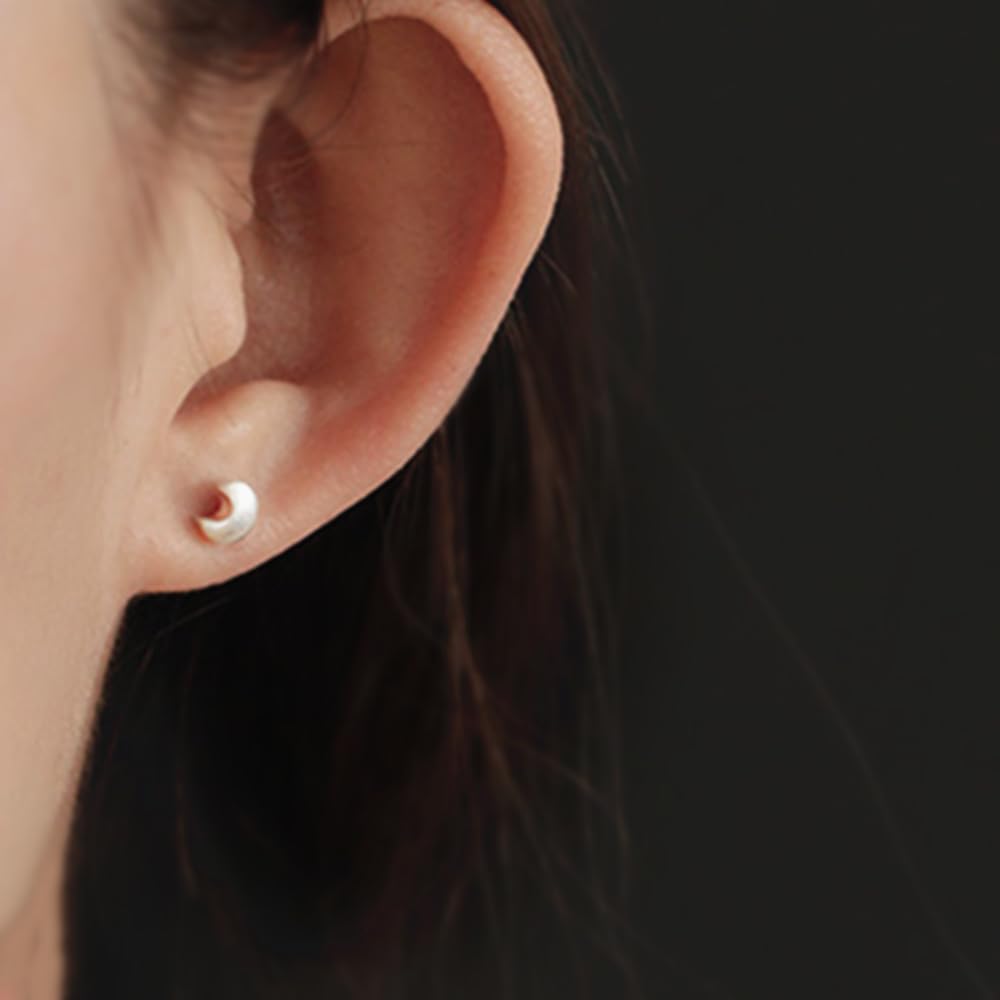 Crescent moon stud earrings on ear, silver-tone, small pair