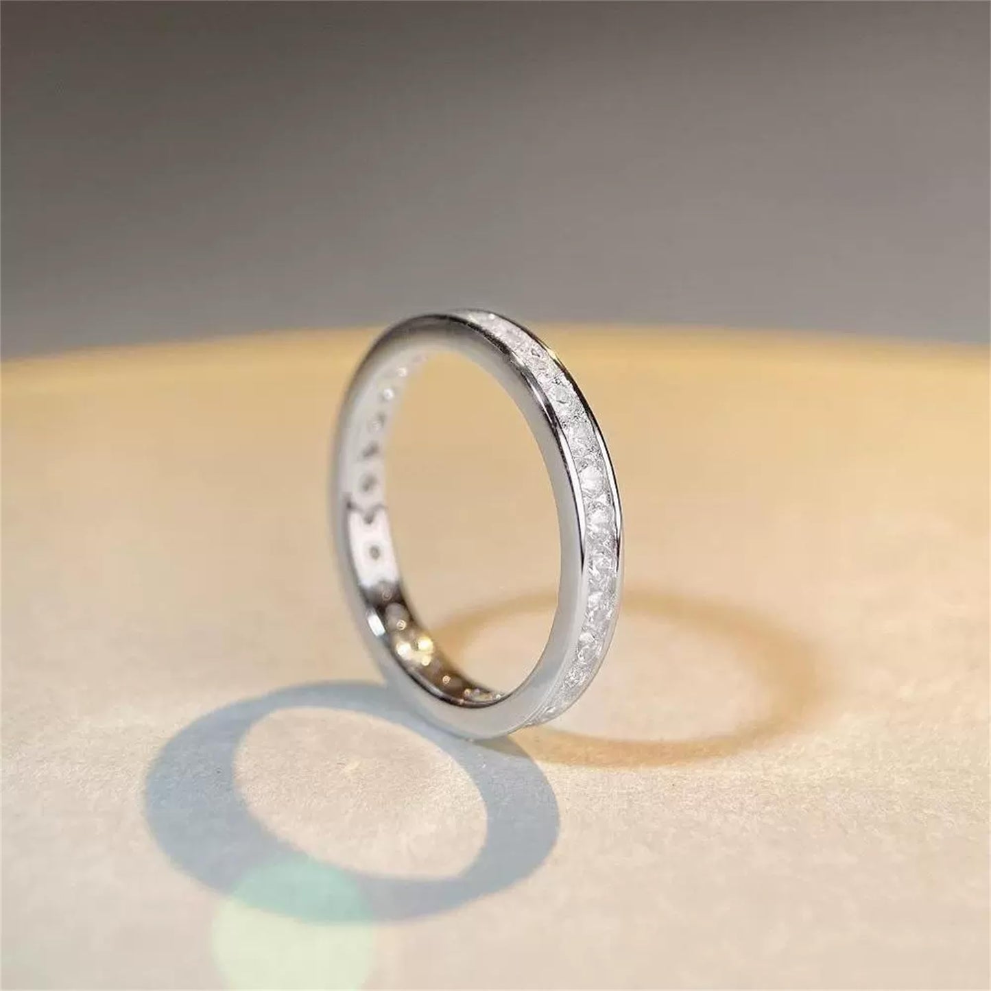 Silver eternity ring viewed from the side, with channel-set stones on the band