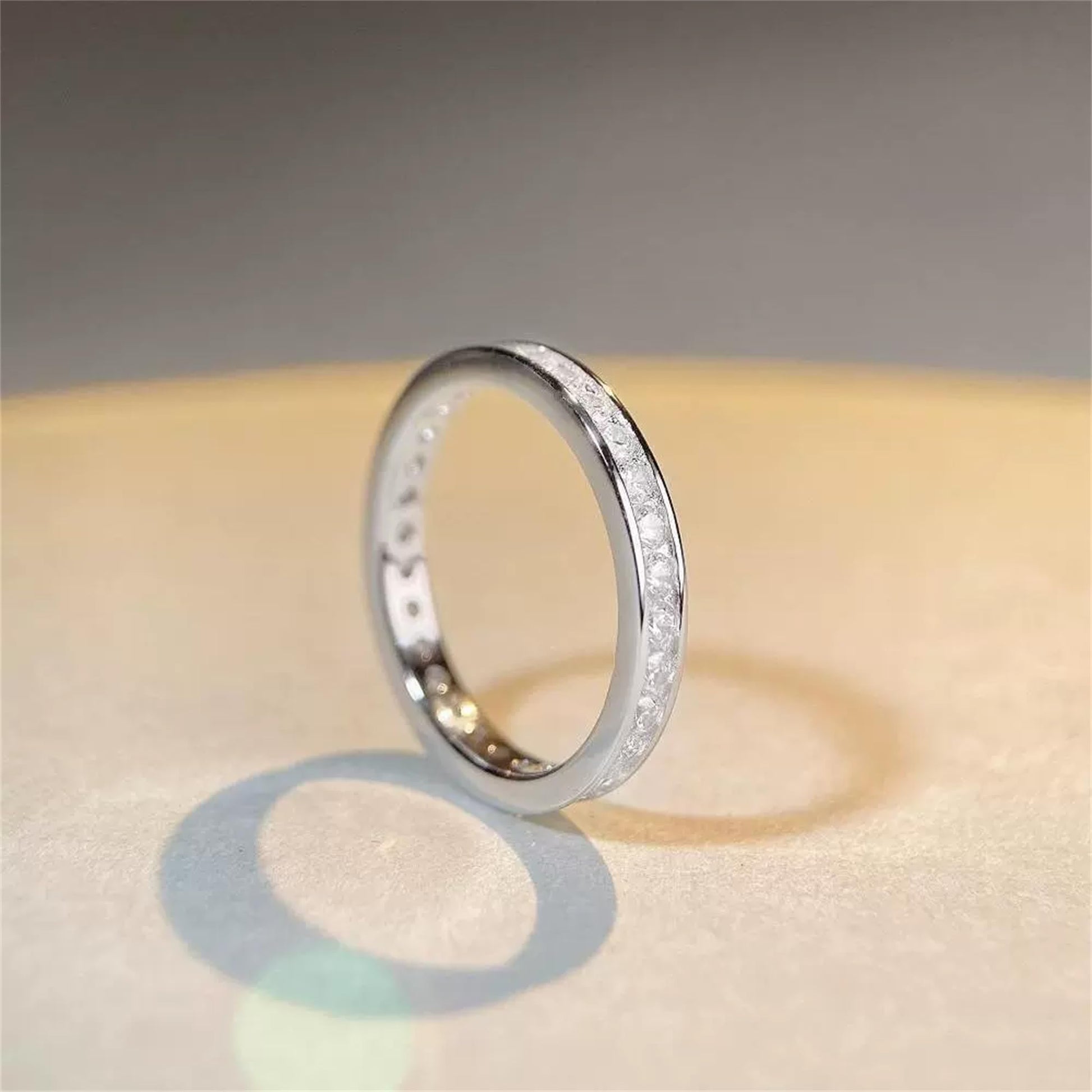 Silver eternity ring viewed from the side, with channel-set stones on the band