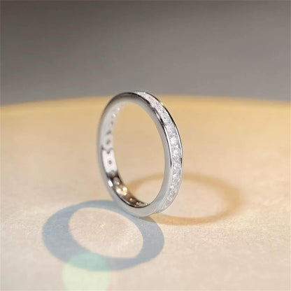 Silver eternity ring viewed from the side, with channel-set stones on the band