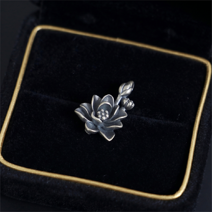 Oxidized lotus flower charm with spiral-style petals and dotted center