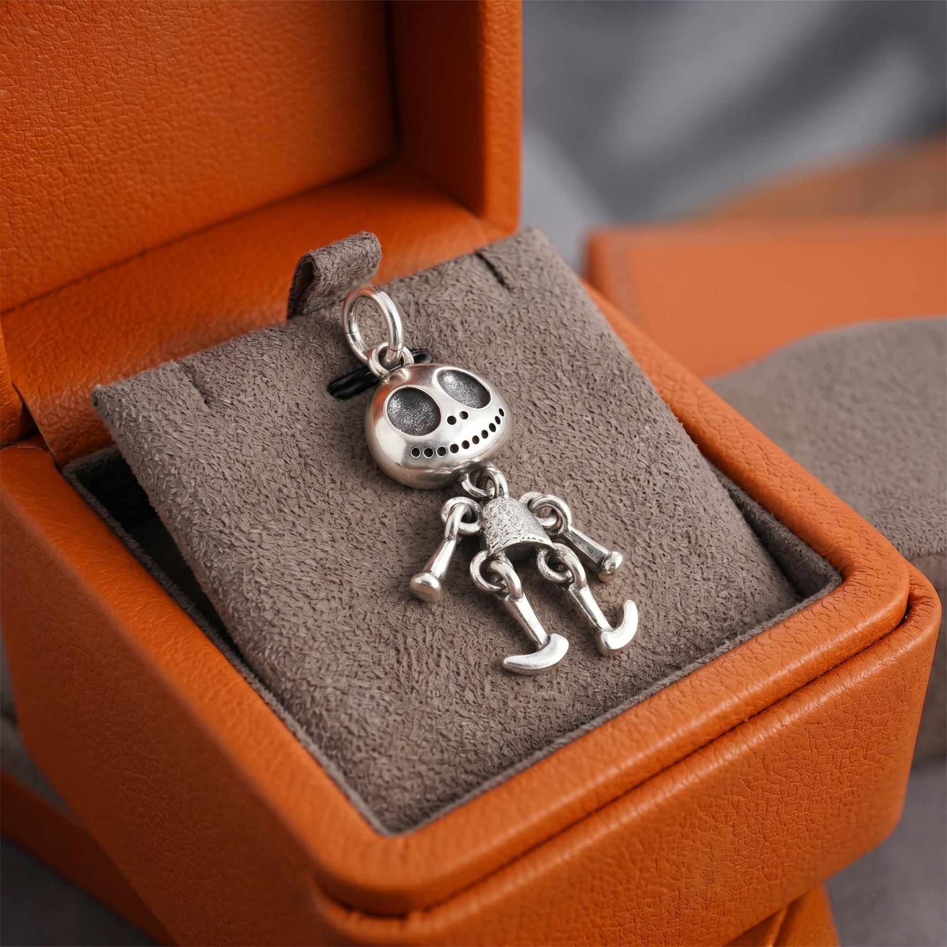 Movable ghost face pendant on display cushion, silver-tone articulated figure