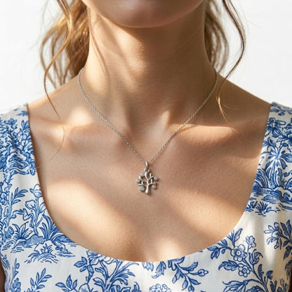 Silver Tree of Life pendant necklace on a person’s collarbone
