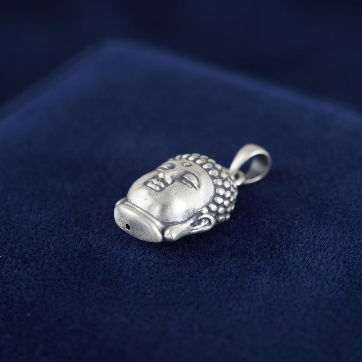 Buddha head pendant showing back/top details, silver-tone