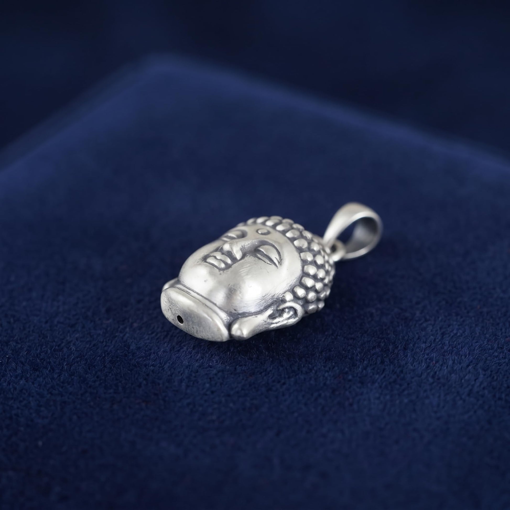 Buddha head pendant showing back/top details, silver-tone