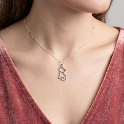 Silver-tone hollow kitten charm pendant on a thin necklace chain at the neckline.