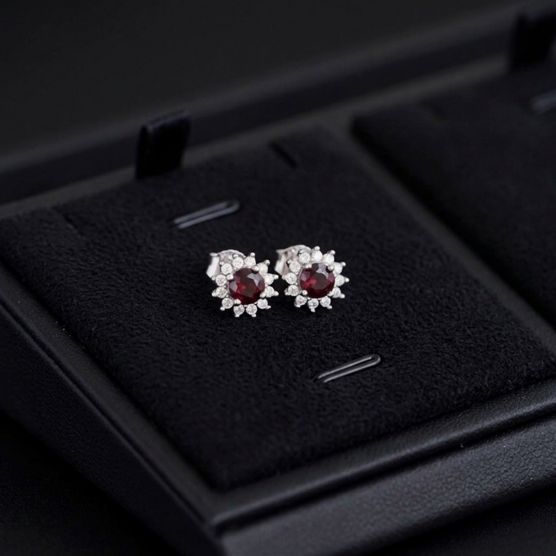 Red oval gemstone cluster earrings in open black jewelry box