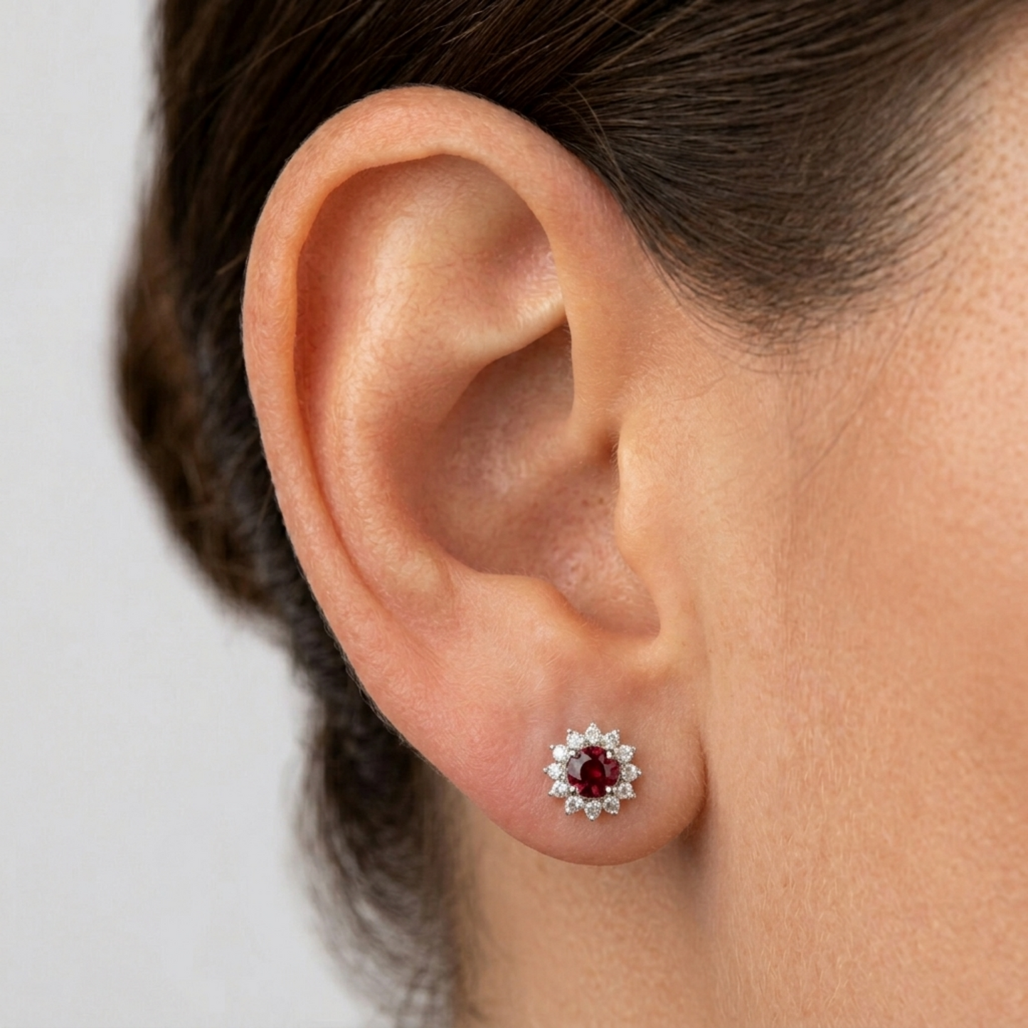 Red oval gemstone cluster earrings worn on ear