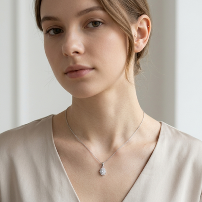 Silver necklace with small white gemstone pendant in cluster setting on model