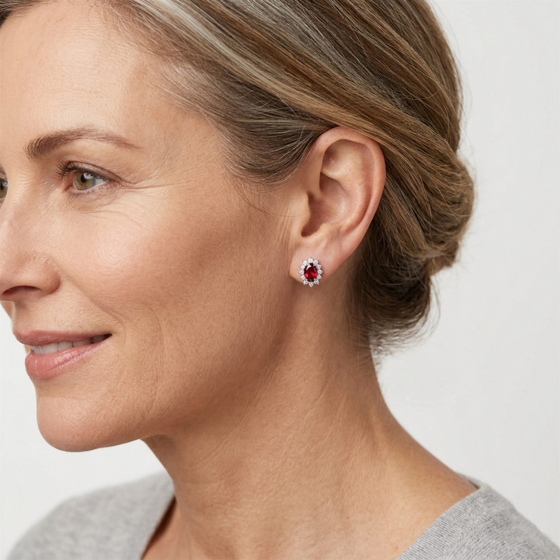 Red oval garnet cluster stud earrings on ear, silver-tone setting