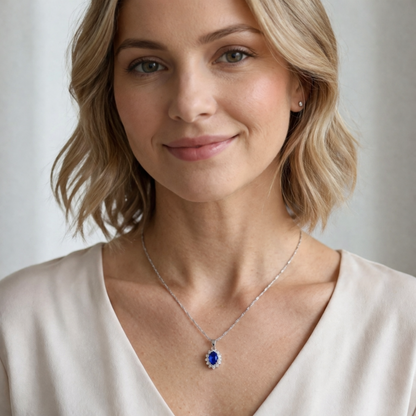 Silver-tone necklace with oval blue gemstone cluster pendant on a thin chain.