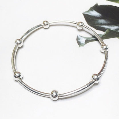 Silver noodle-style stretch bracelet with round bead accents