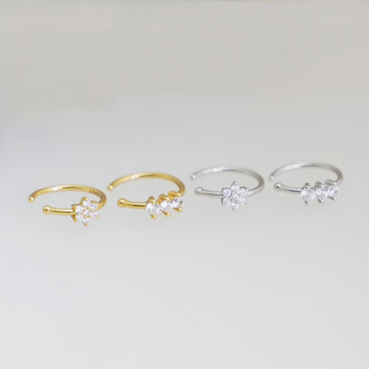 Four CZ cuff hoop rings with floral clusters in gold and silver finishes.