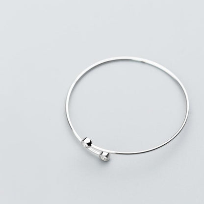 Silver-tone open torque bangle with two round CZ stones at opposite ends