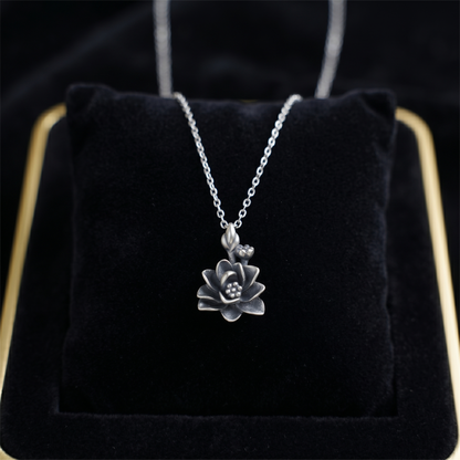 Silver necklace with oxidized lotus pendant featuring dotted center and loop bail