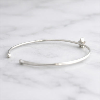 Silver star charm torque bangle bracelet with star detail near clasp
