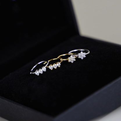 CZ floral cuff hoops in a jewelry box: one gold-tone and one silver-tone.