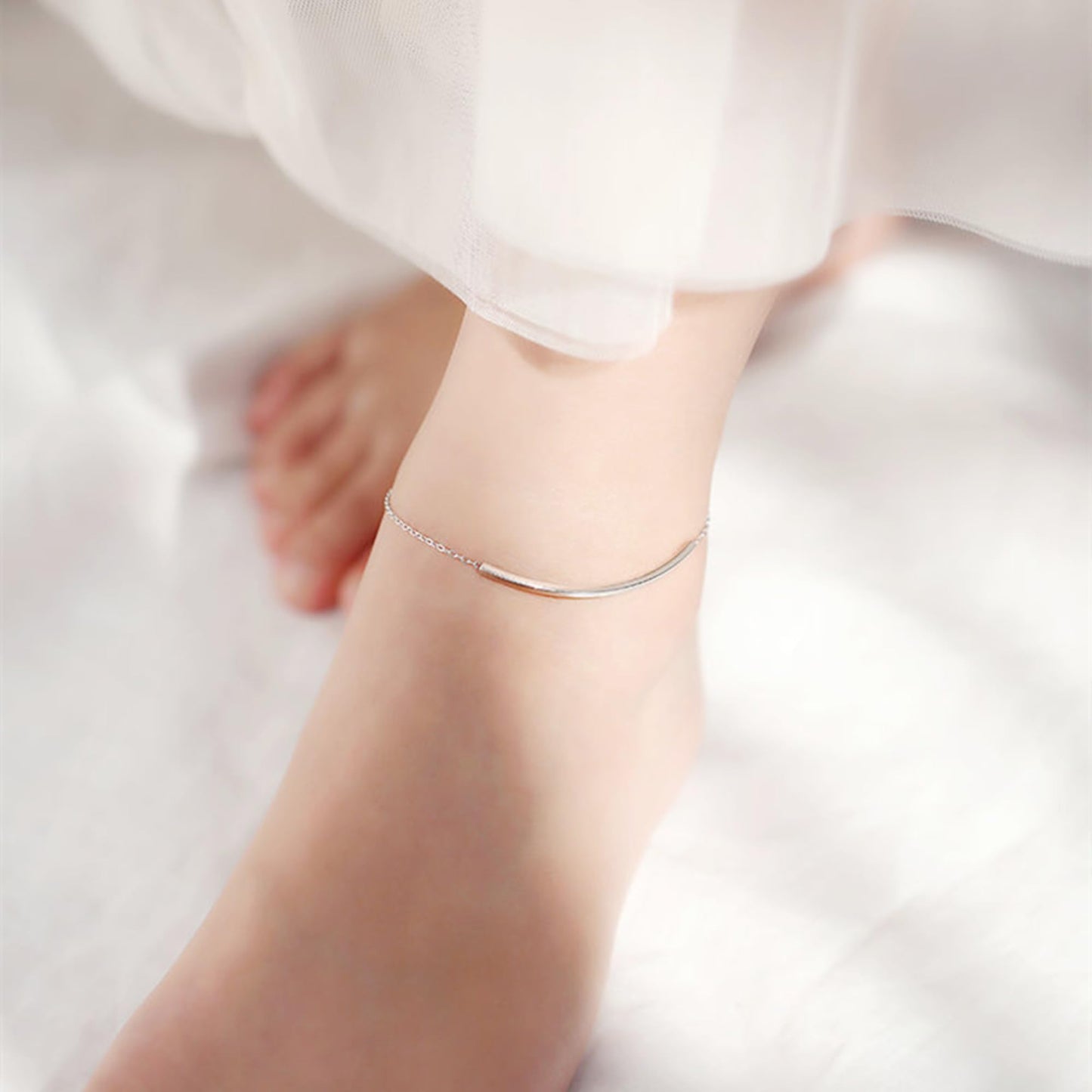 Silver curb chain anklet with curved bar on ankle
