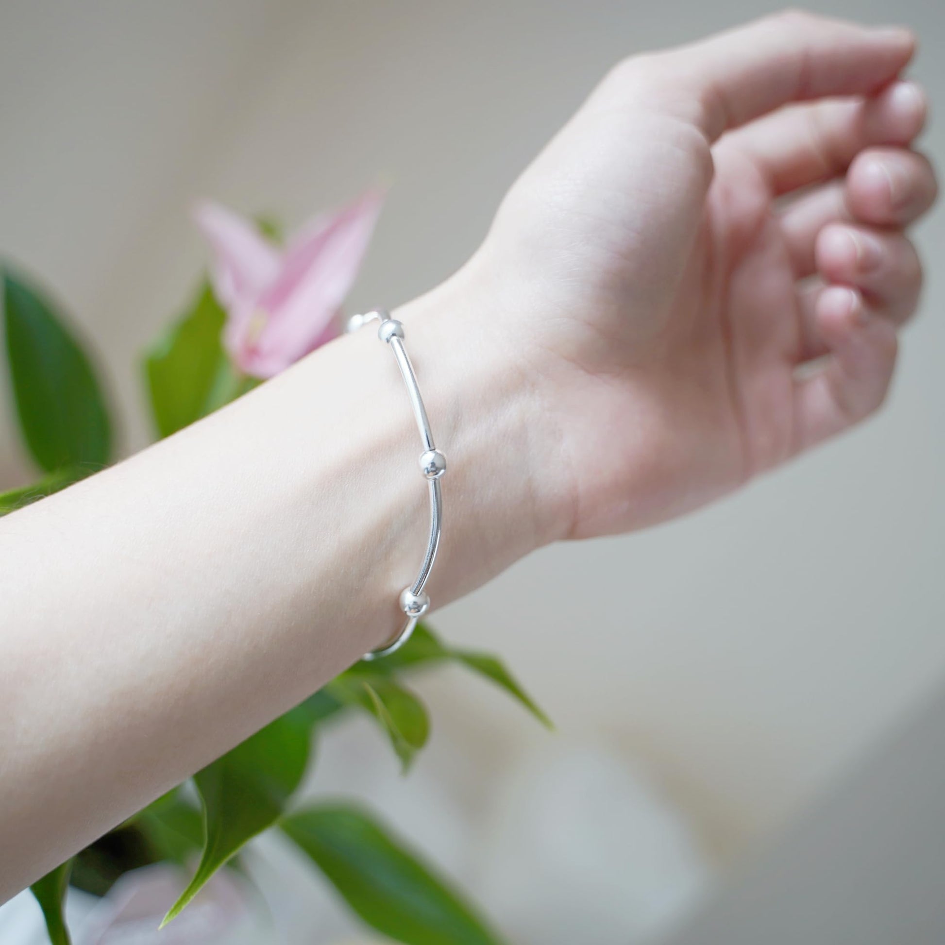 Silver bead stretch bracelet worn on wrist, close to hand