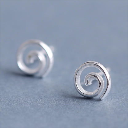 Silver spiral swirl stud earrings, close-up of round back and curled center.