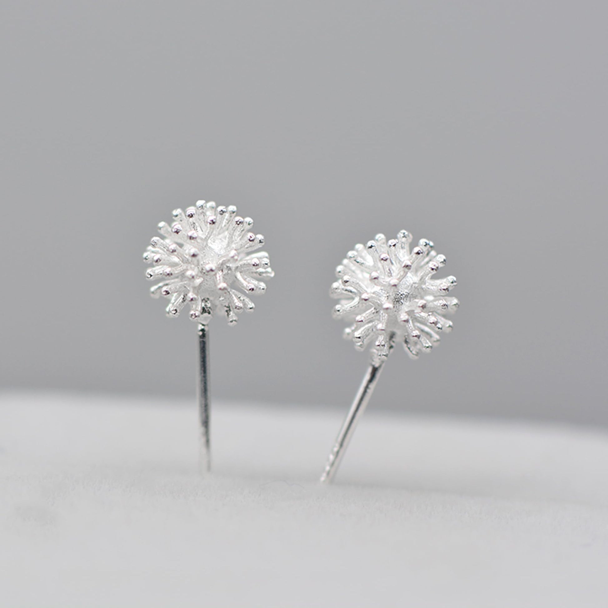 Dandelion flower stud earrings with silver-toned posts and rhinestone-like spiky petals