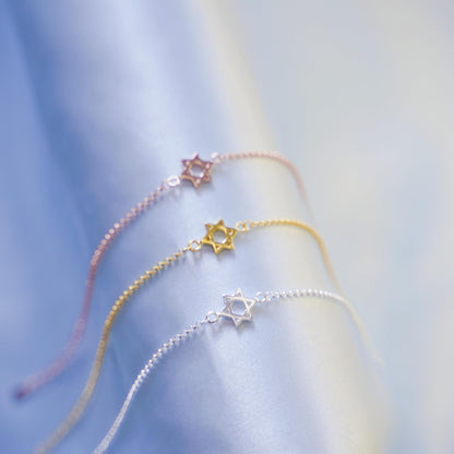 Star of David charm bracelets in rose gold, gold, and silver tones with star charms