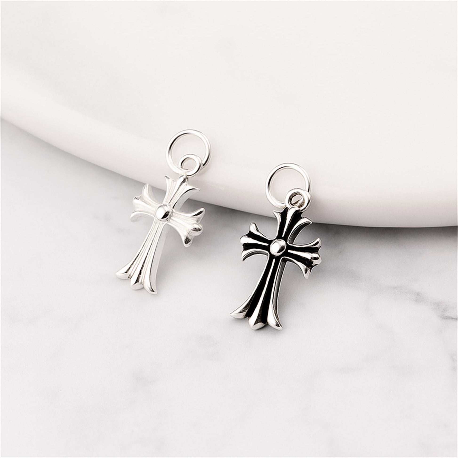 Two-tone fleur-de-lis cross charms on loop hooks, plain silver and oxidised silver