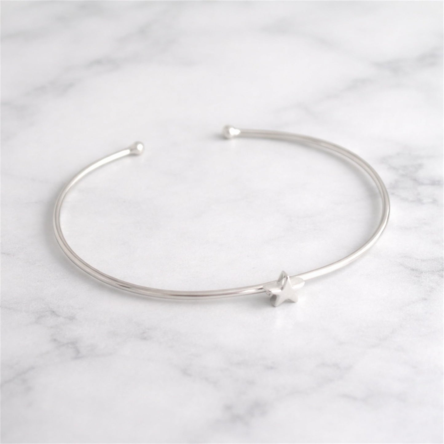 Silver star charm bangle bracelet with open ends and star accent