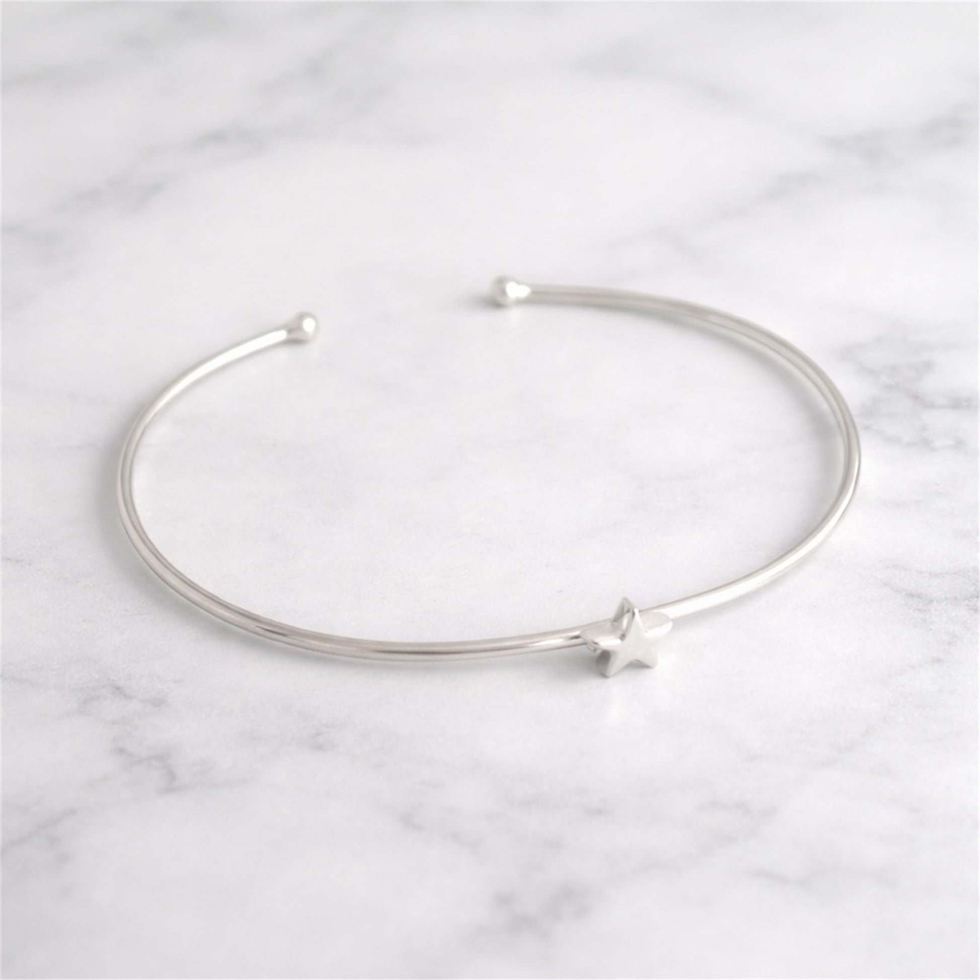 Silver star charm bangle bracelet with open ends and star accent