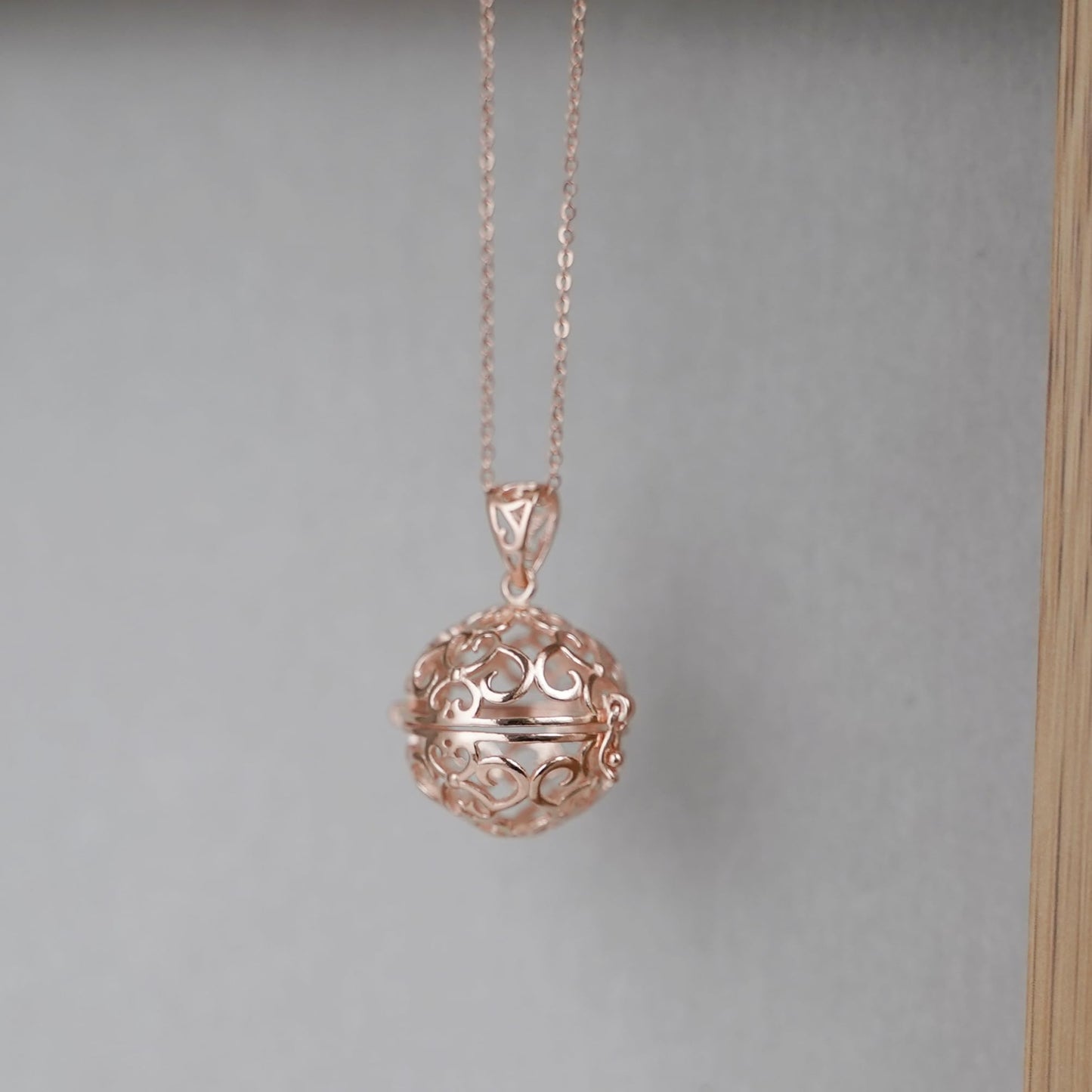Rose gold-tone necklace with round filigree ball charm and link chain