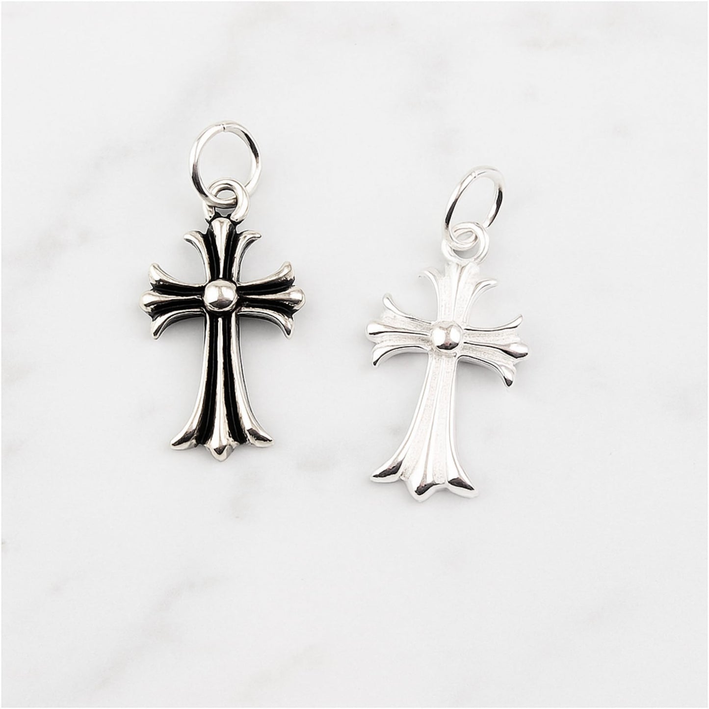 Fleur-de-lis cross charm hook earrings, one plain silver and one oxidised silver