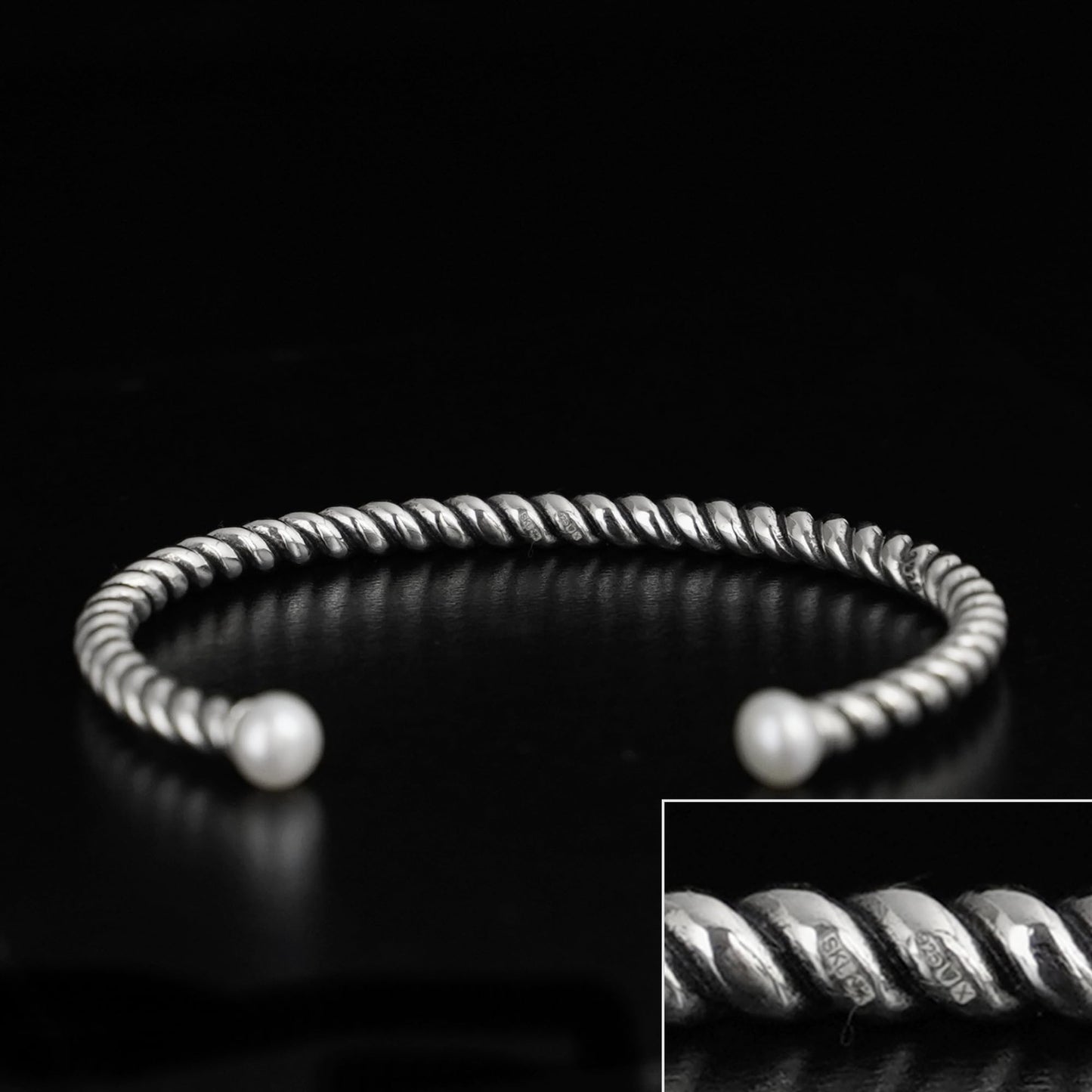 Pearl twisted torque bangle with ridged silver wire and two white pearl tips.