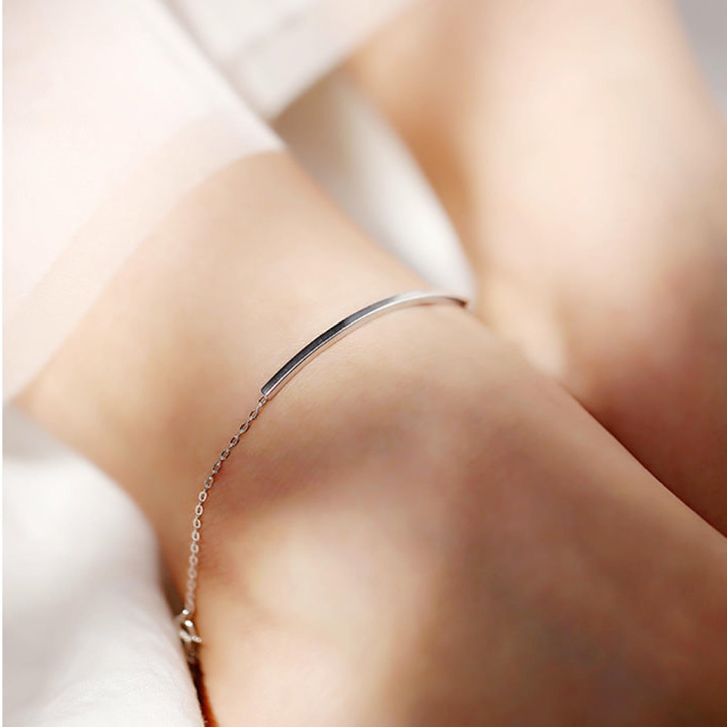 Silver curved tube bar anklet on ankle