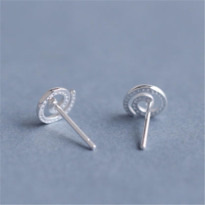 Silver spiral swirl stud earrings, round swirl face with visible straight posts.