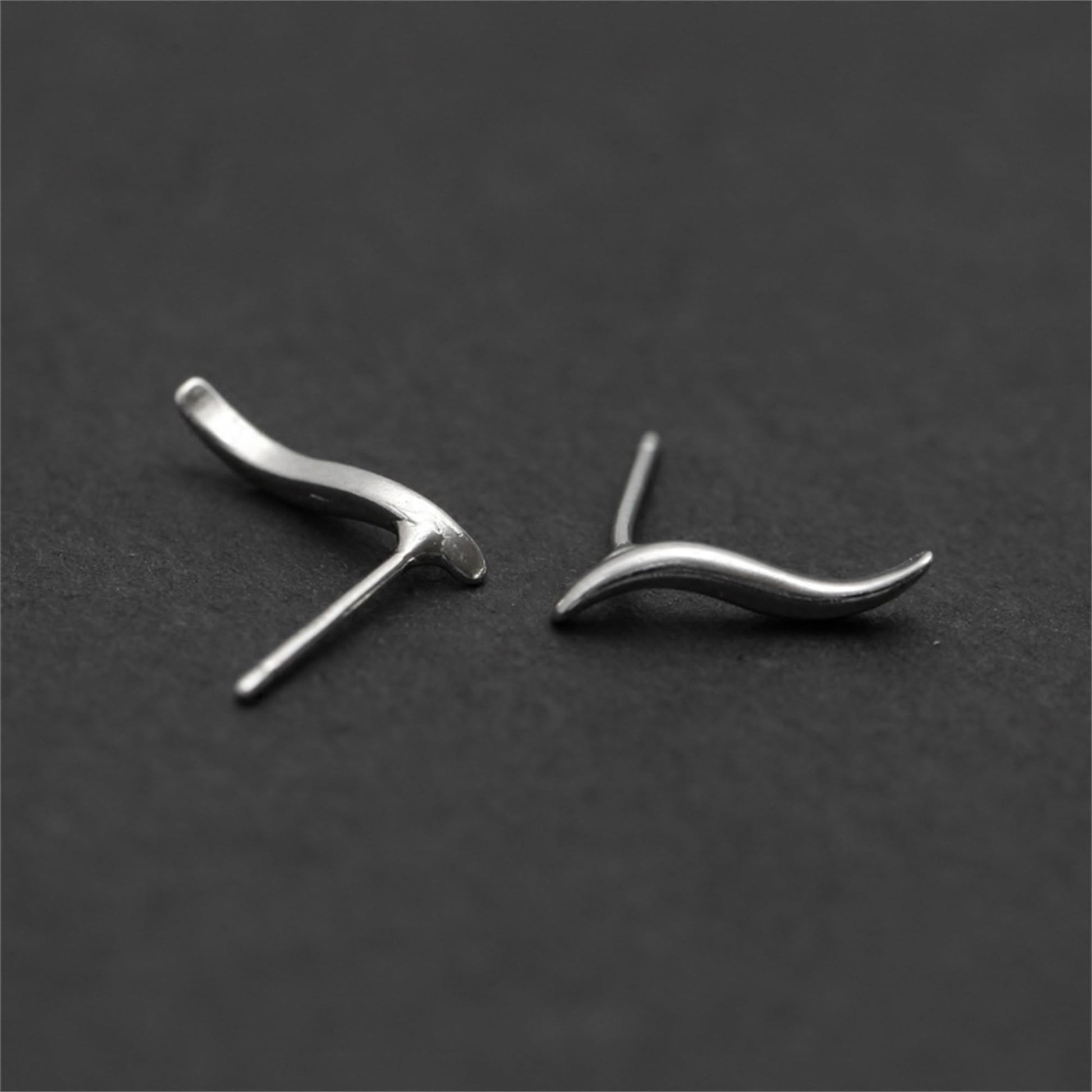 Silver wavy vine climber stud earrings shown at angles with post backing