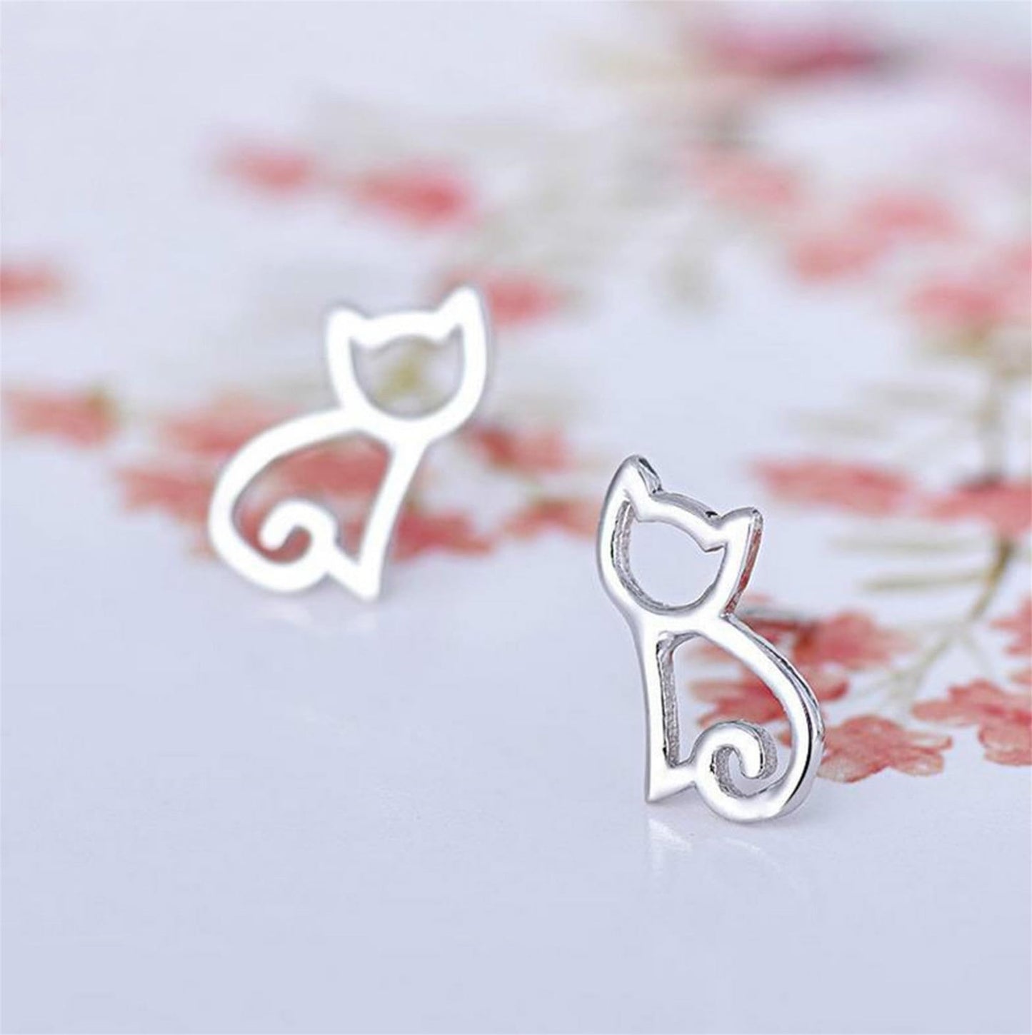 Silver-tone cat outline stud earrings with small curled tail details