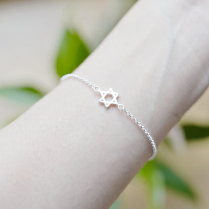 Silver-tone Star of David charm bracelet on wrist with linked bead chain