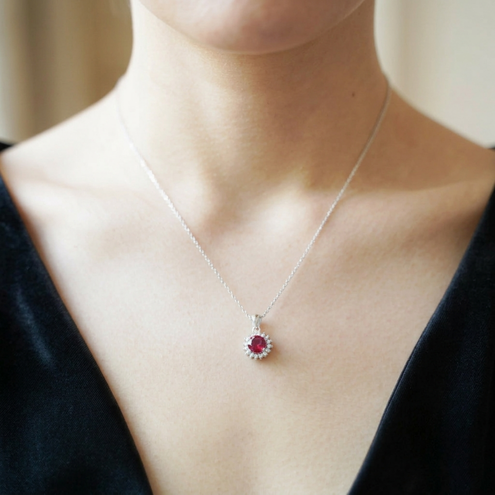 Silver necklace with small round red gemstone pendant on fine chain
