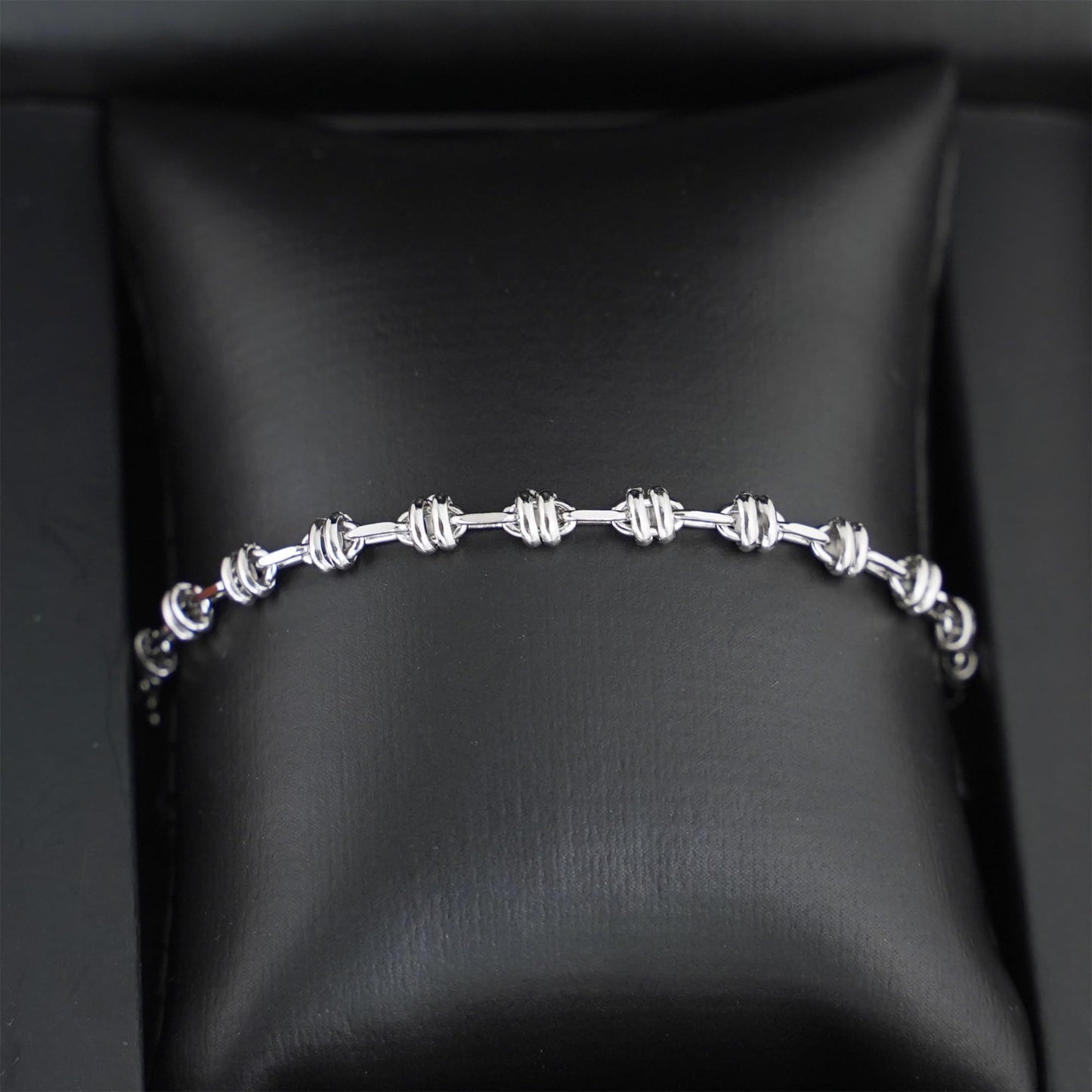 Silver-tone rope curb chain bracelet on black box lining, oval links and clasp