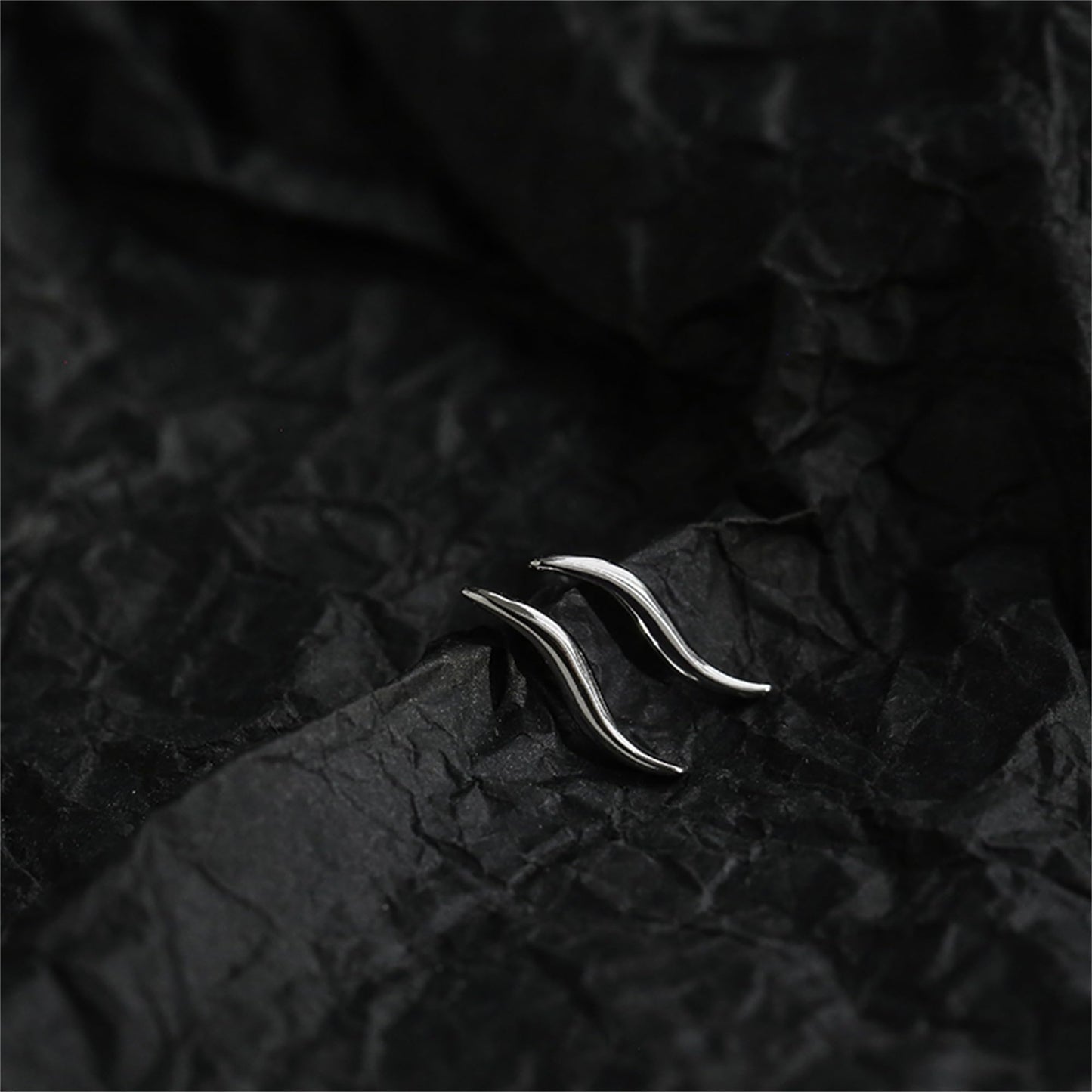 Silver wavy vine climber stud earrings with glossy curved vine surface