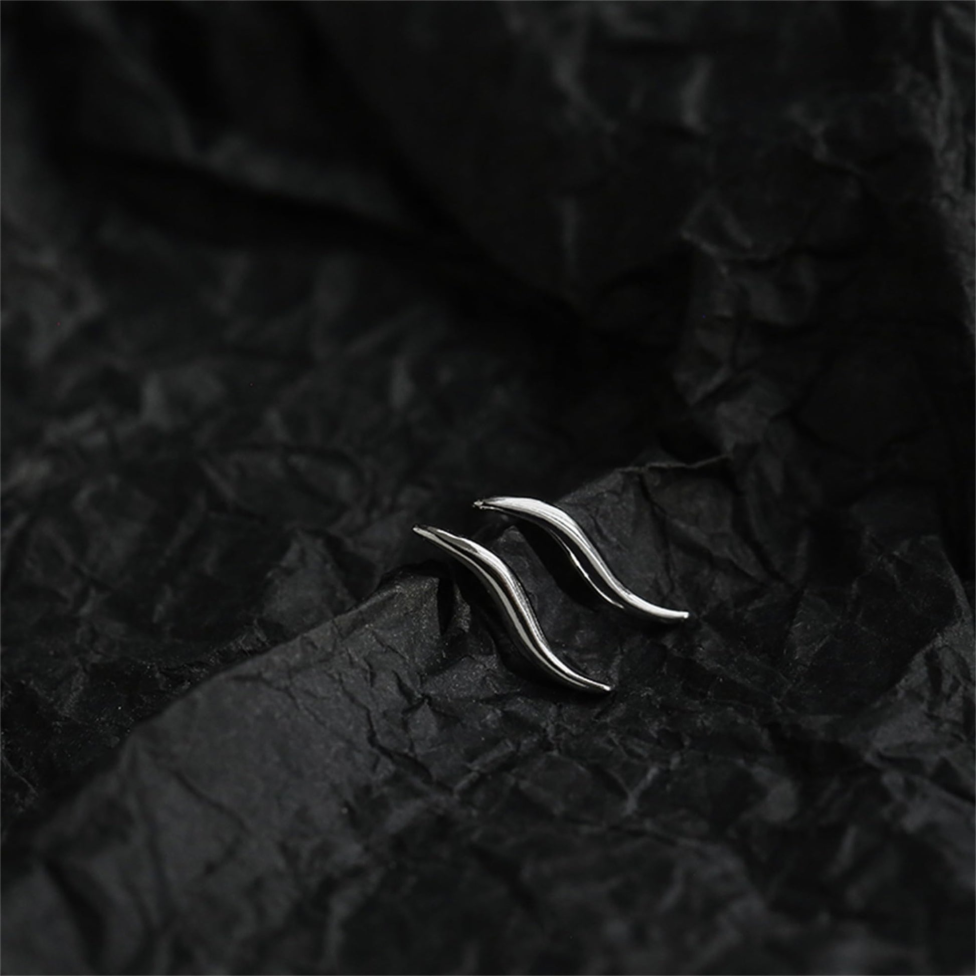 Silver wavy vine climber stud earrings with glossy curved vine surface